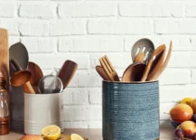utensil holder on kitchen counter with white brick background