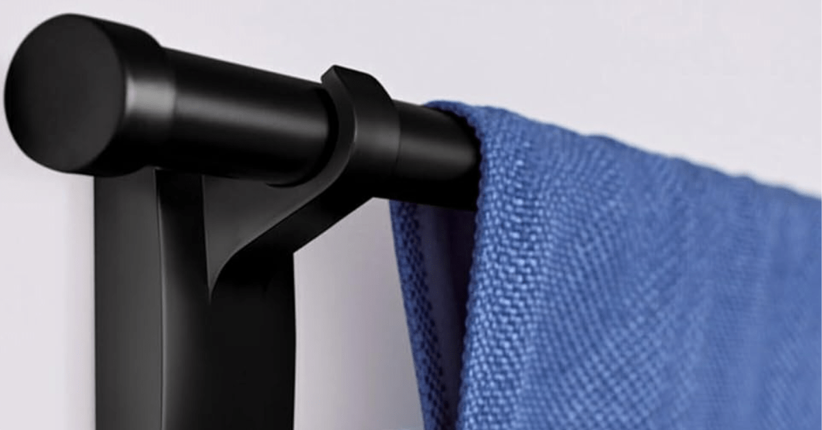 A black curtain hook put on with adhesive.