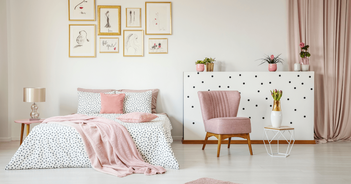 A white and pink bedroom with pink chair.