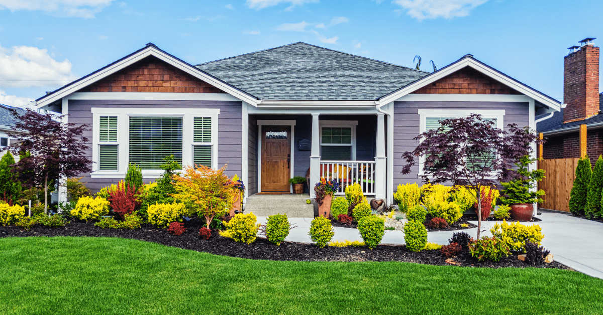 A house exterior with well kept landscaping.