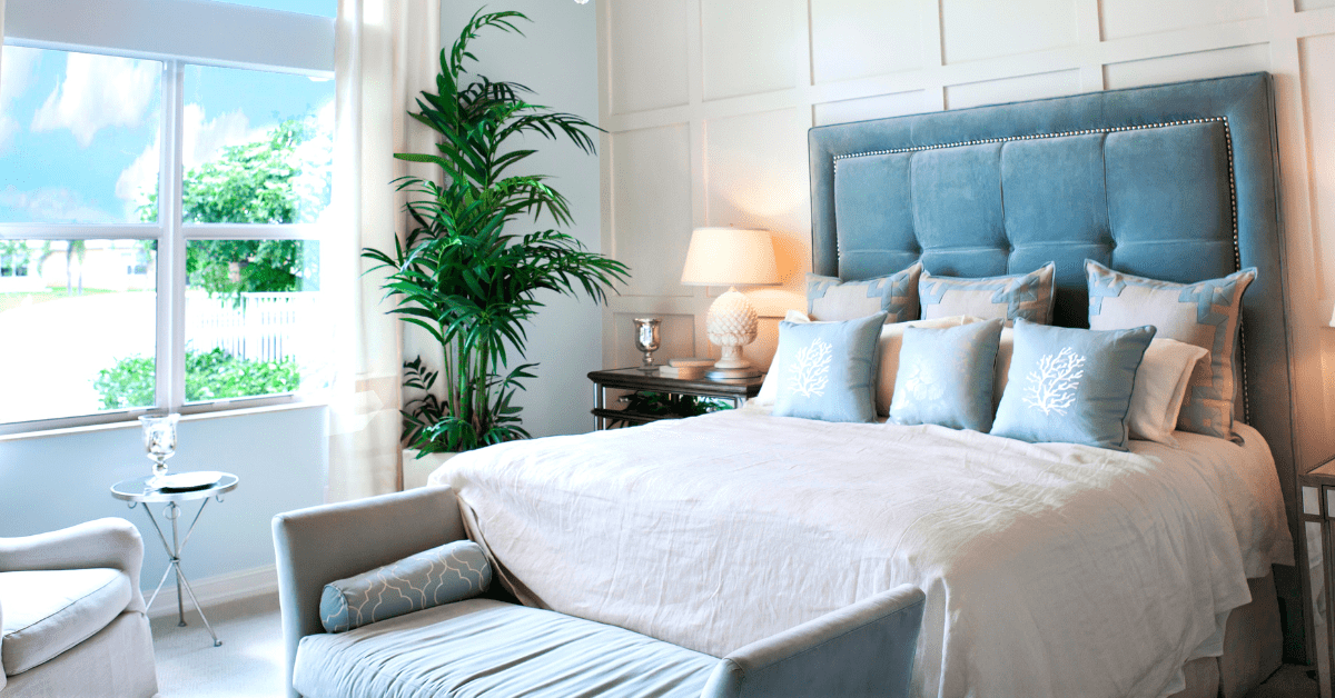 A bedroom with blue accents and bright bedding.