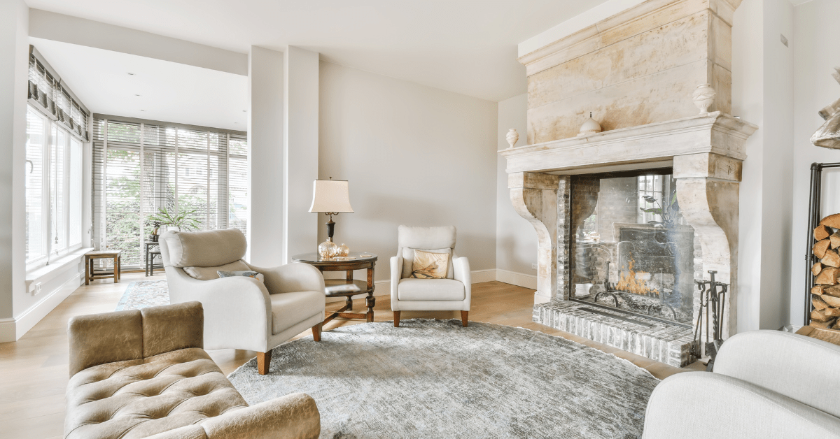 A living room with neutral color decor and luxurious fire place.
