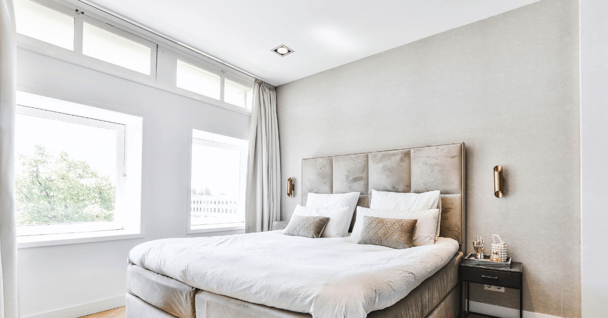 A bedroom with light grey walls and white ceilings with lightpods.