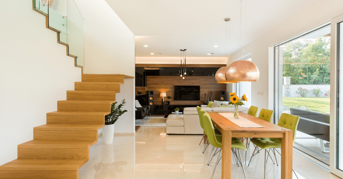 A modern staircase with a living room dining room combo to its side.