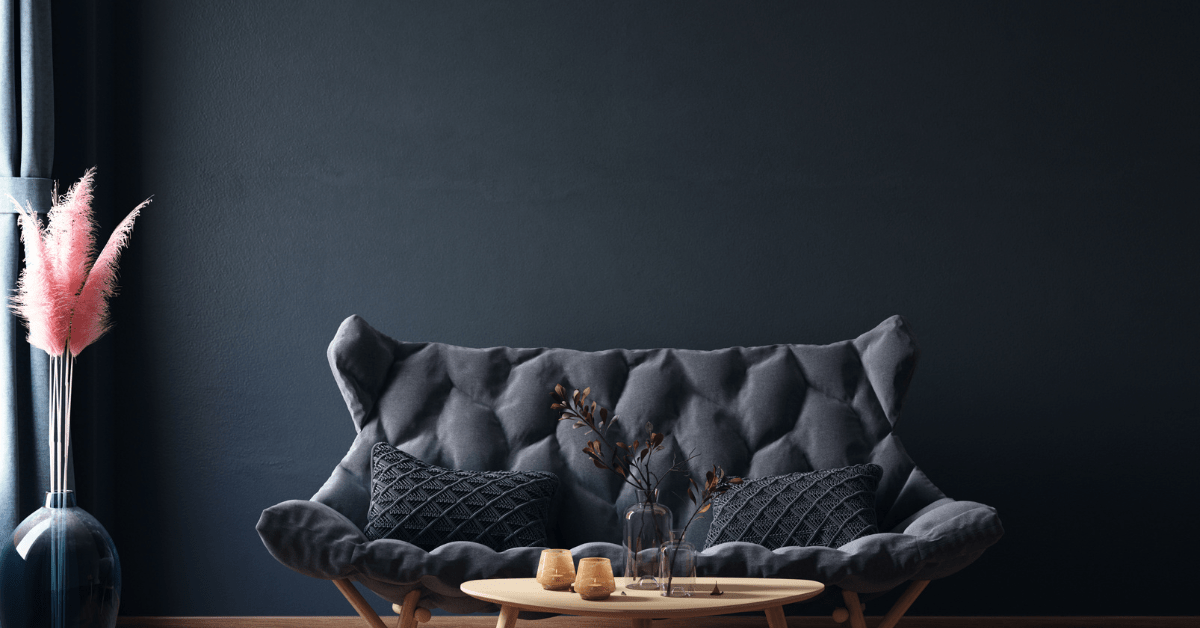 Black painted wall with a dark black couch.