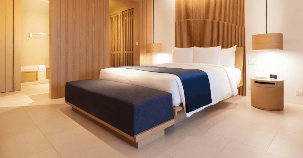 A modern bed with wood headboard.