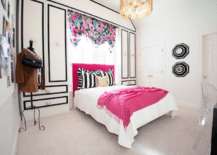 Glamorous teenage girls bedroom with black, white and pink color scheme. Teen girl's bedroom with white and black cabinets and white and black cornice box framing hot pink headboard. Hot Pink velvet headboard with white and black awning stripe ruffled pillows. White cabinets with black trim and brass hardware flanking bed and floral valance over bed. Bed in front of window covered in floral valance layered over plantation shutters. Worlds Away Chrialto Pendant Chandelier over bed.Teen girl's bed with white coverlet, black and white striped ruffled pillows, gold accent pillow and pink fringed throw at foot of bed. White walls with bold black and white octagonal mirrors between doorways. Worlds Away ChRialto Chandelier Pendant hangs over bed.
