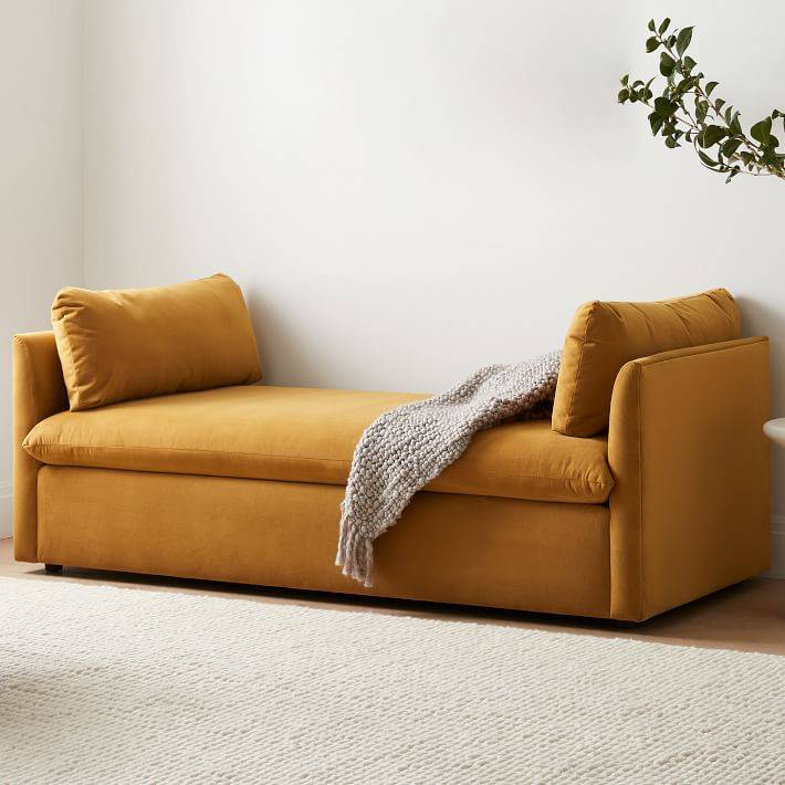 mustard yellow day bed with no back in white living room