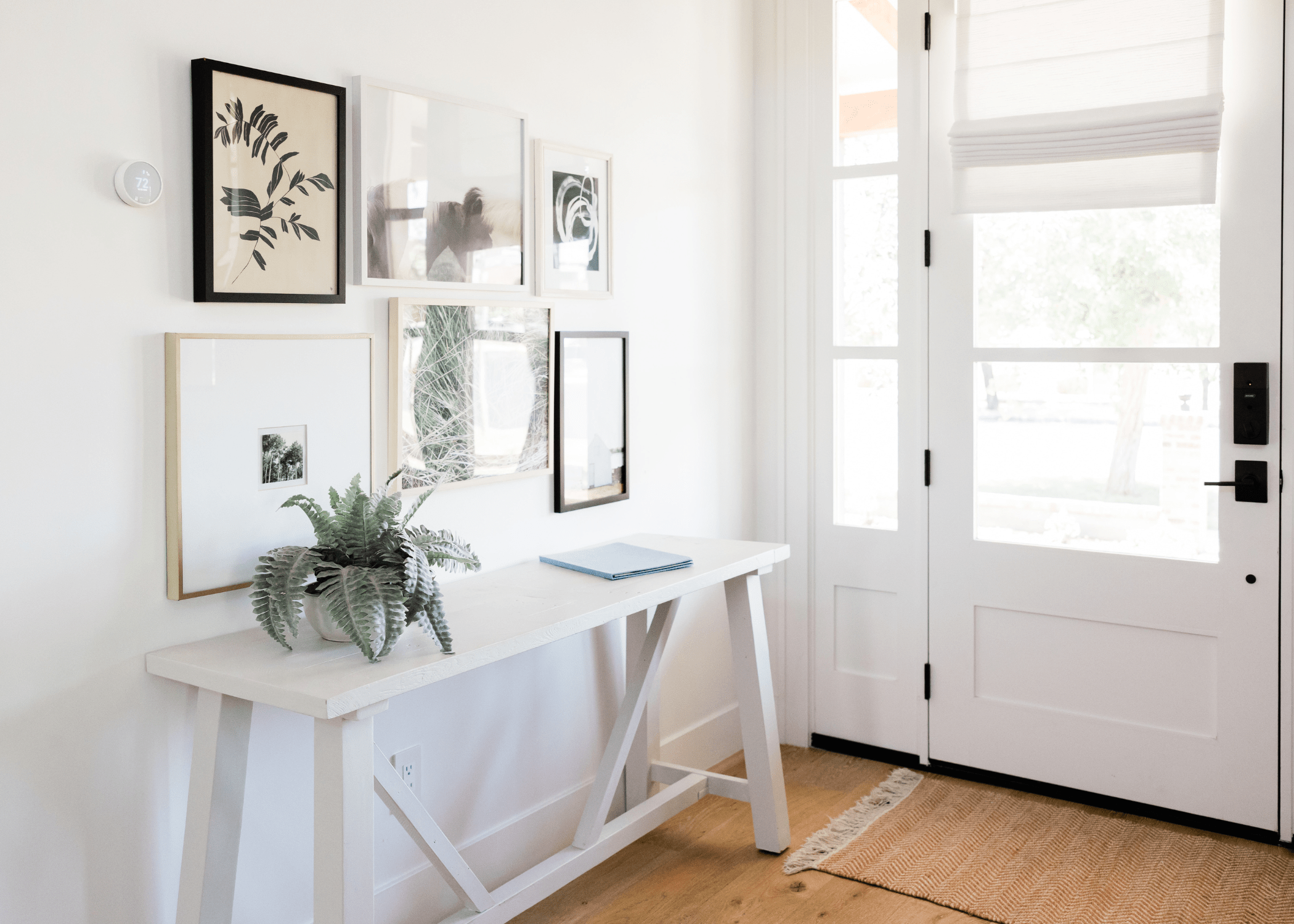 white entry way with table and gallery wall