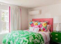 Fantastic pink and green teen girl's bedroom features a pink headboard on queen bed dressed in white and pink hotel bedding and a green Chinese dragon blanket placed next to a single nightstand, green campaign nightstand with brass trim, topped with a Bungalow 5 Mariah White Table Lamp.