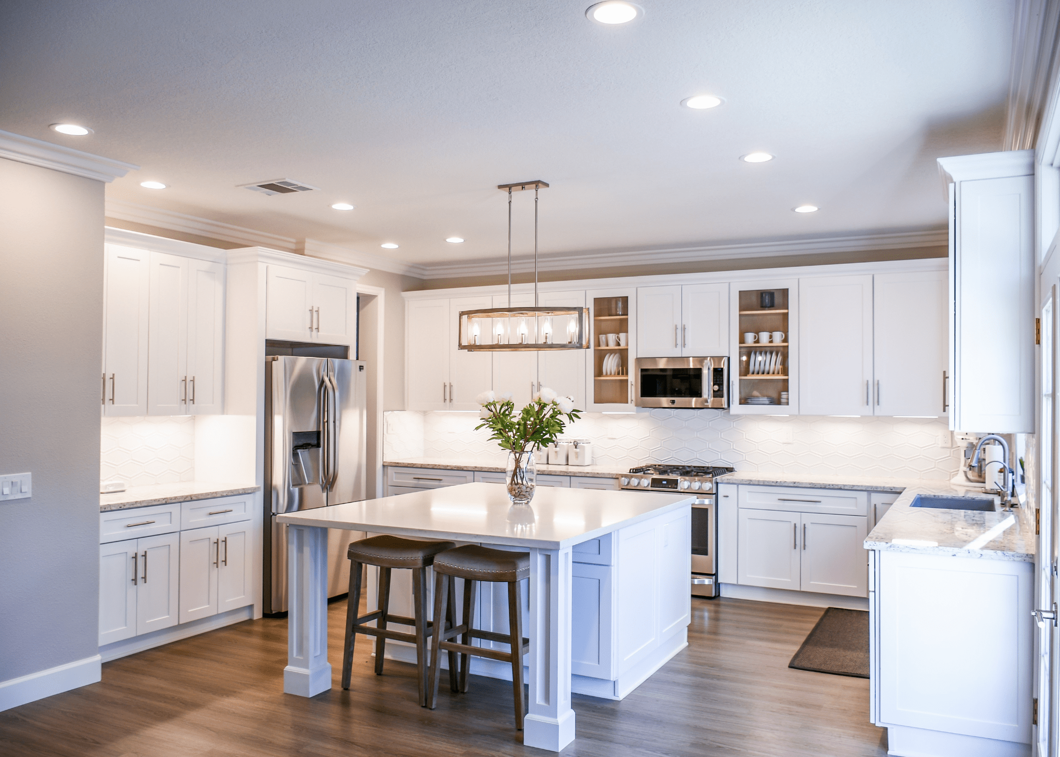 white kitchen cabinets, with center island and stainless steel appliances