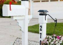 white pillar mailbox and white solar light with planters