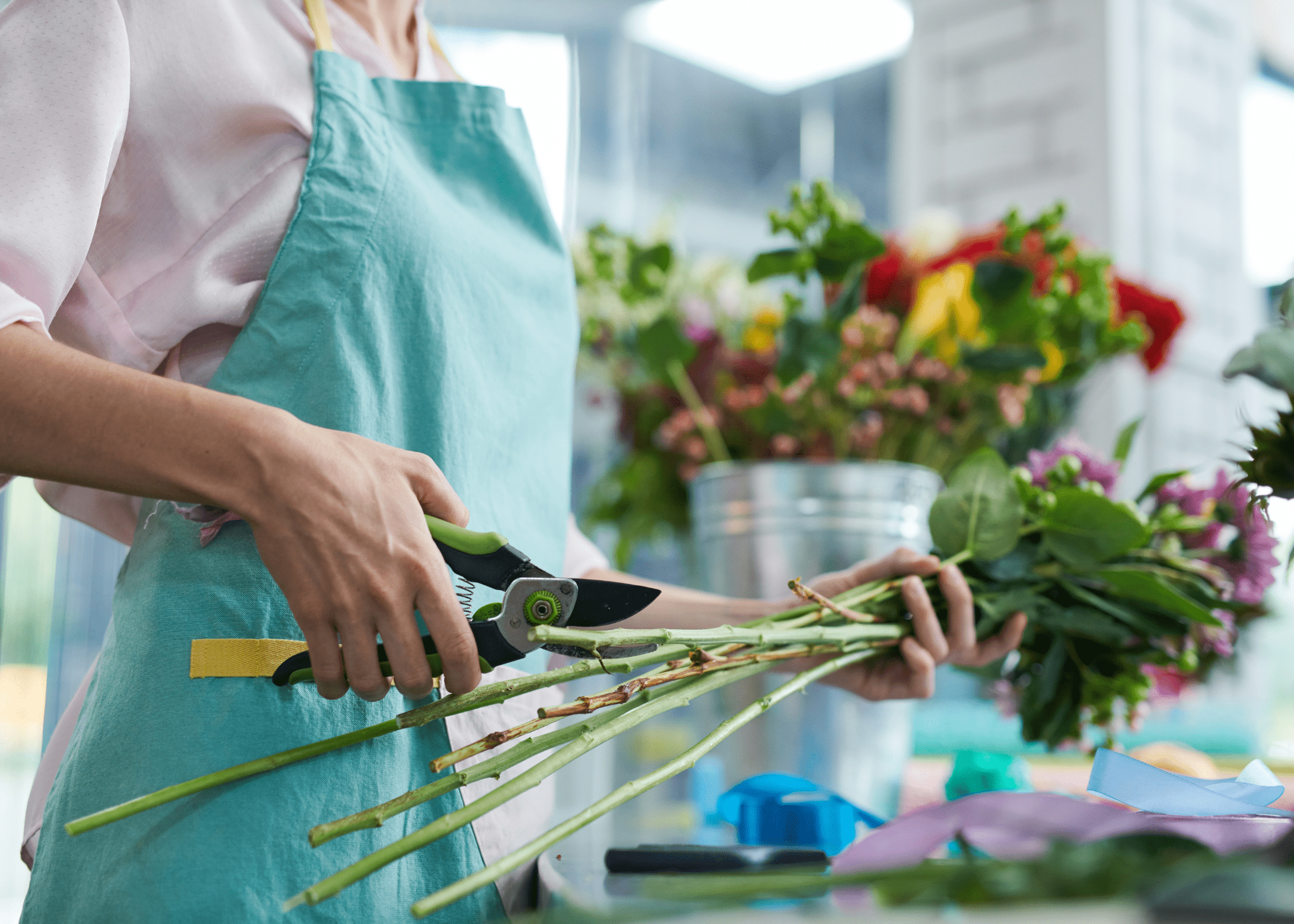 woman wearing apron trimming floral stems