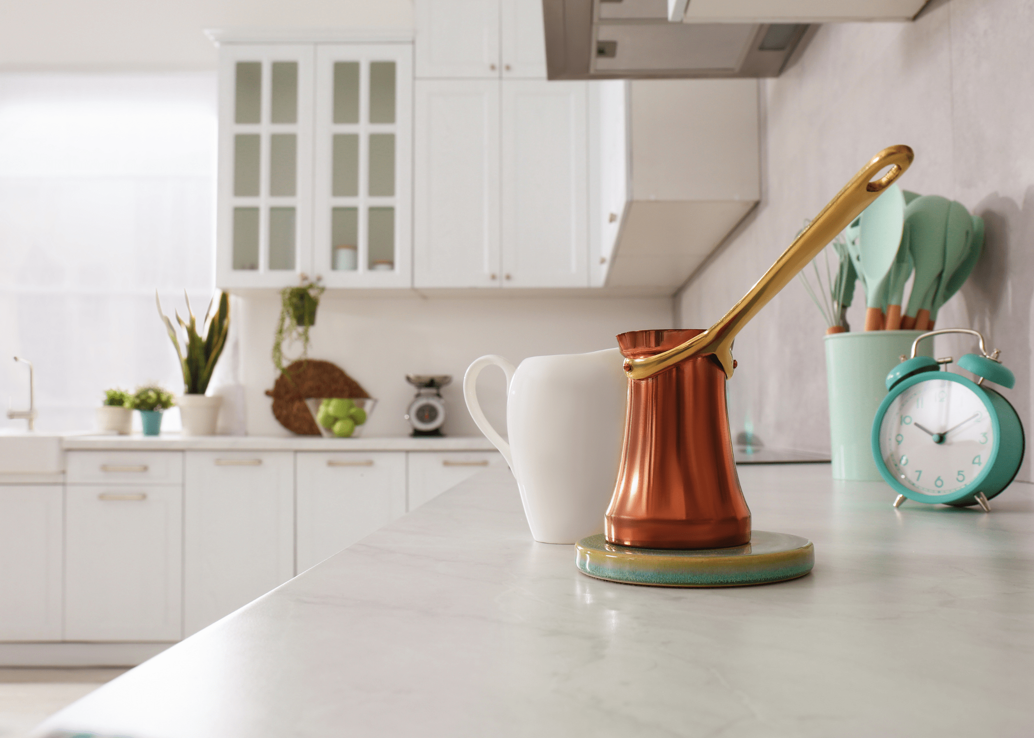 close up of laminate counters in white kitchen with copper pot and white creamer sea foam green utensils