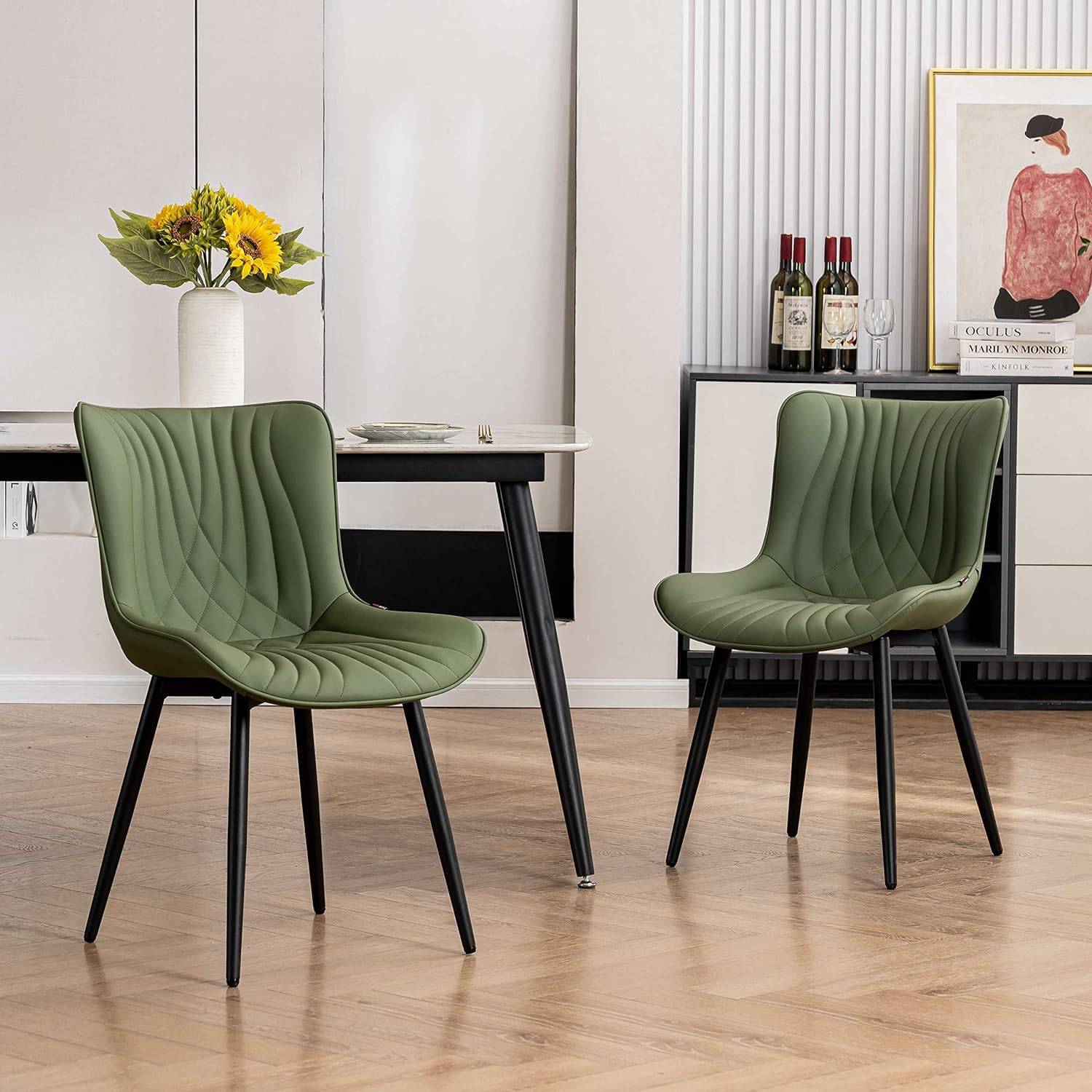 Green modern chairs in a living room with black legs.