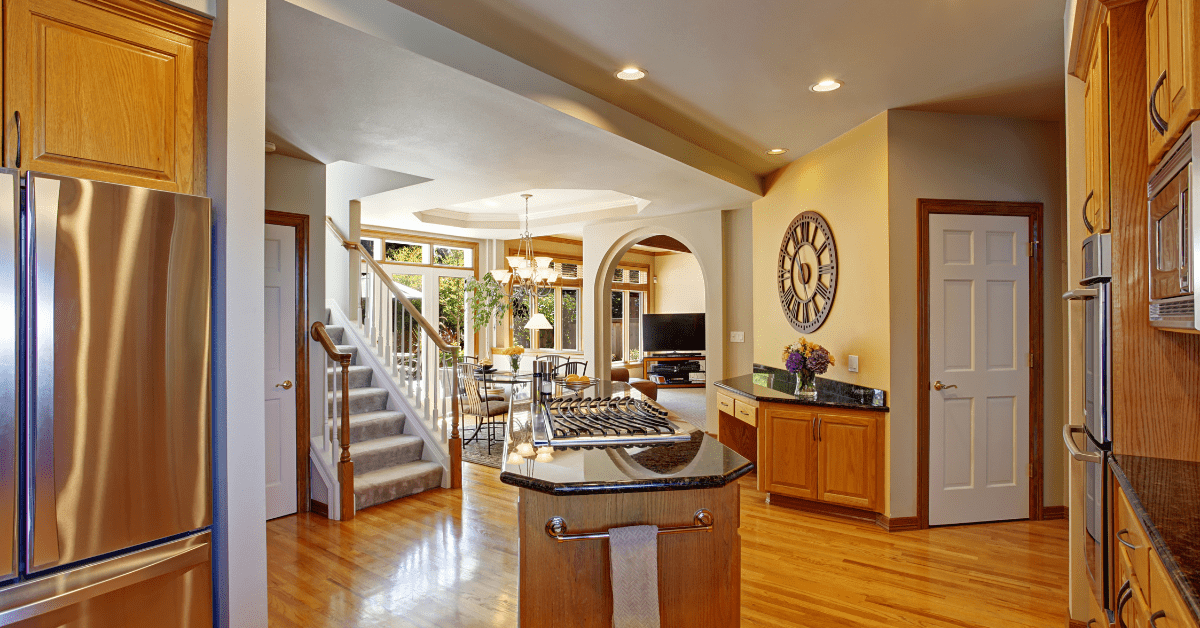 A large kitchen with an island in the center that features a built-in stove.