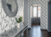 A hallway with grey wallpaper and stylish decor.