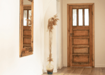 A rustic hallway with wooden accents and wall mounted mirror.