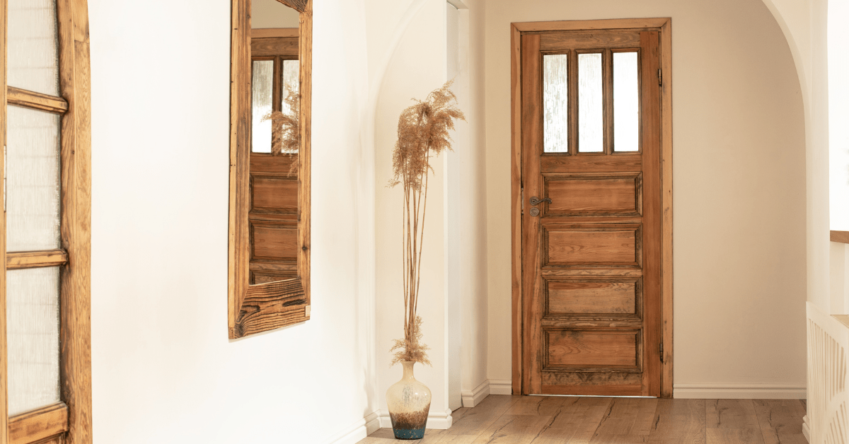 A rustic hallway with wooden accents and wall mounted mirror.