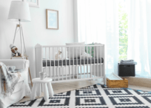 White small nursery room with black and white rug.