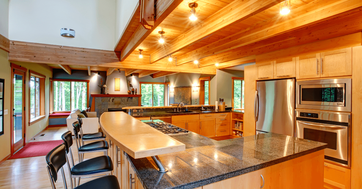 A traditional kitchen with wood ceiling and bright lights.