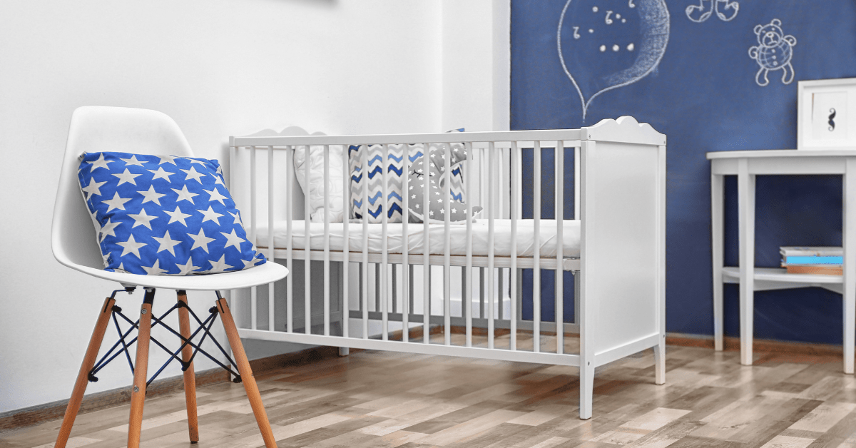 White and blue small nursery with a chair holding a pillow with stars.