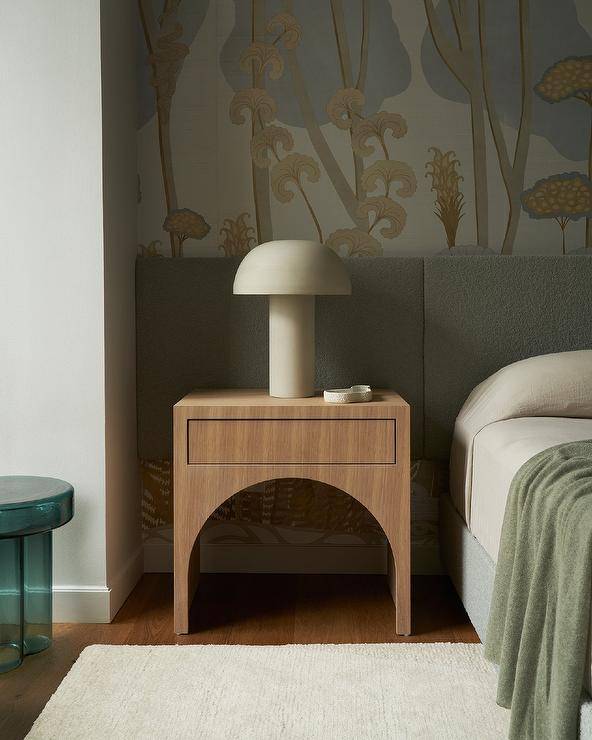 Bedroom features a mushroom lamp on a brown arch nightstand in a bed nook with yellow and gray wallpaper.