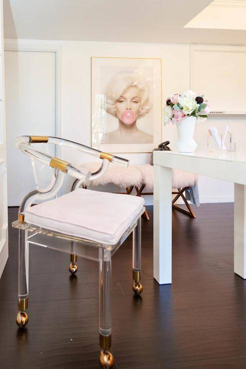 Lucite and brass chair on wheels at a white desk in a home office finished with contemporary and chic decor.