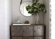 Entryway alcove with walls painted Benjamin Moore Gray Owl framing a Pottery Barn Arden Locker topped with stacked books and a miniature bust alongside a glass vase full of greenery with captains style mirror above.