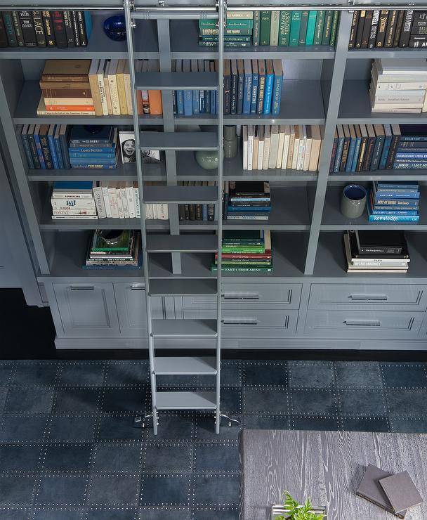 Morgan Harrison Home - A gray ladder sits on a blue suede grid rug and leans against gray built-in bookshelves fixed over gray cabinets in a stunning contemporary blue and gray home office.