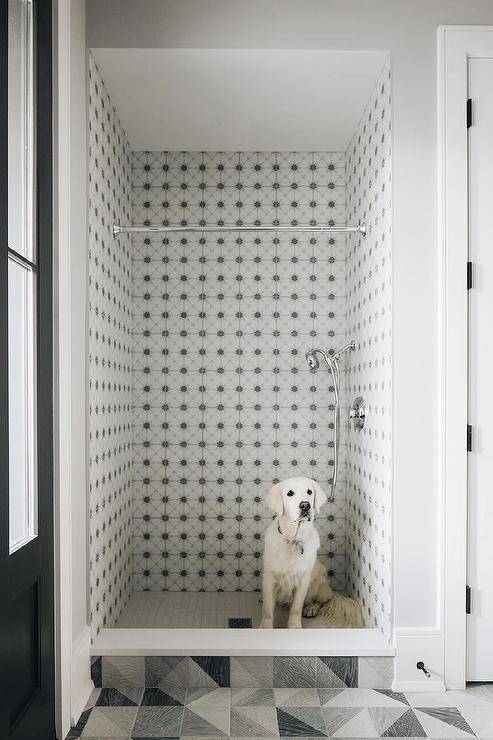 Black and white mosaic surround tiles accent a dog shower finished with a polished nickel sprayer.