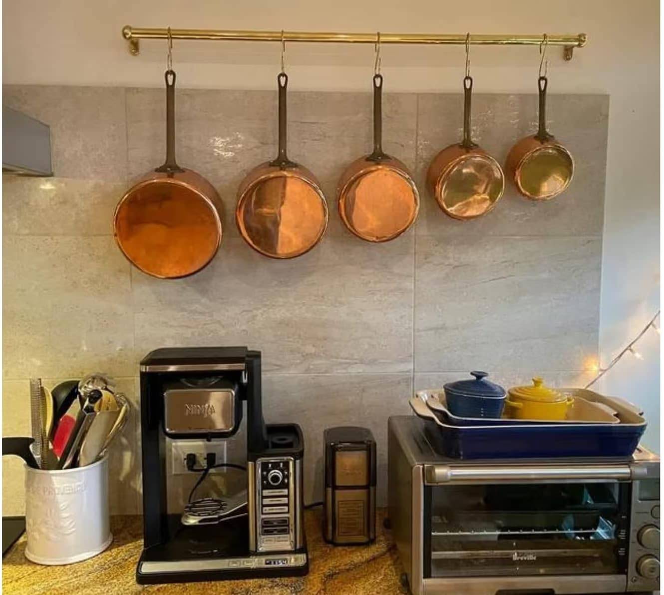 hanging pot rack with copper pots in kitchen.