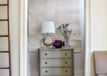 Gorgeous foyer with schoolhouse pendant, tapestry, gray washed chest and gray walls.