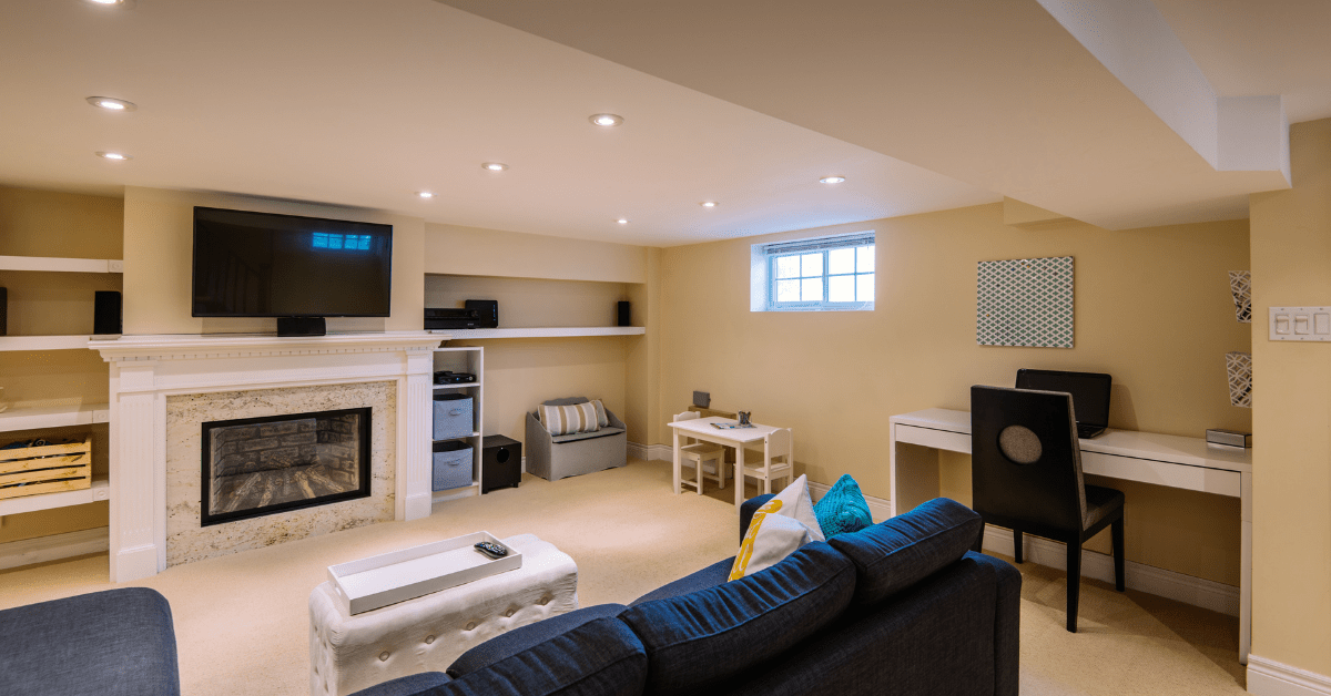 A bright modern basement with blue couch.