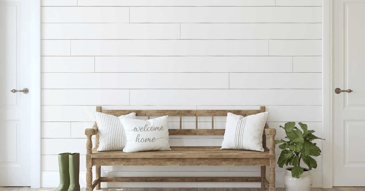 A rustic bench with white throw pillows.