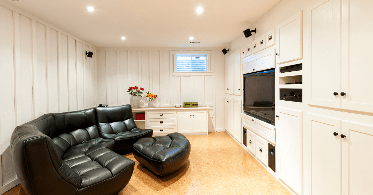 Black leather couches in a modern basement.