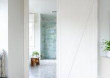 A shiplap barn door on rails slides open to reveal a stunning master bathroom.