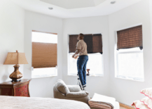 man handing blinds in bedroom