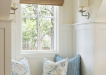 Bedroom features a mini window seat nook with gray pinstriped bench cushion lit by silver leaf flower sconces.