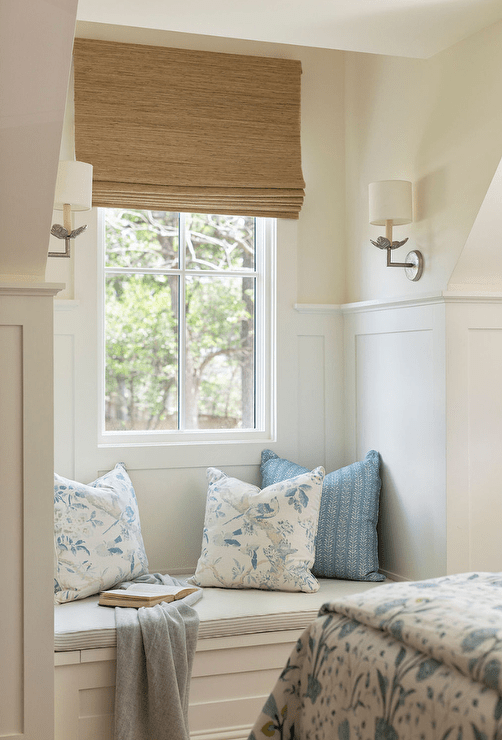 Bedroom features a mini window seat nook with gray pinstriped bench cushion lit by silver leaf flower sconces.