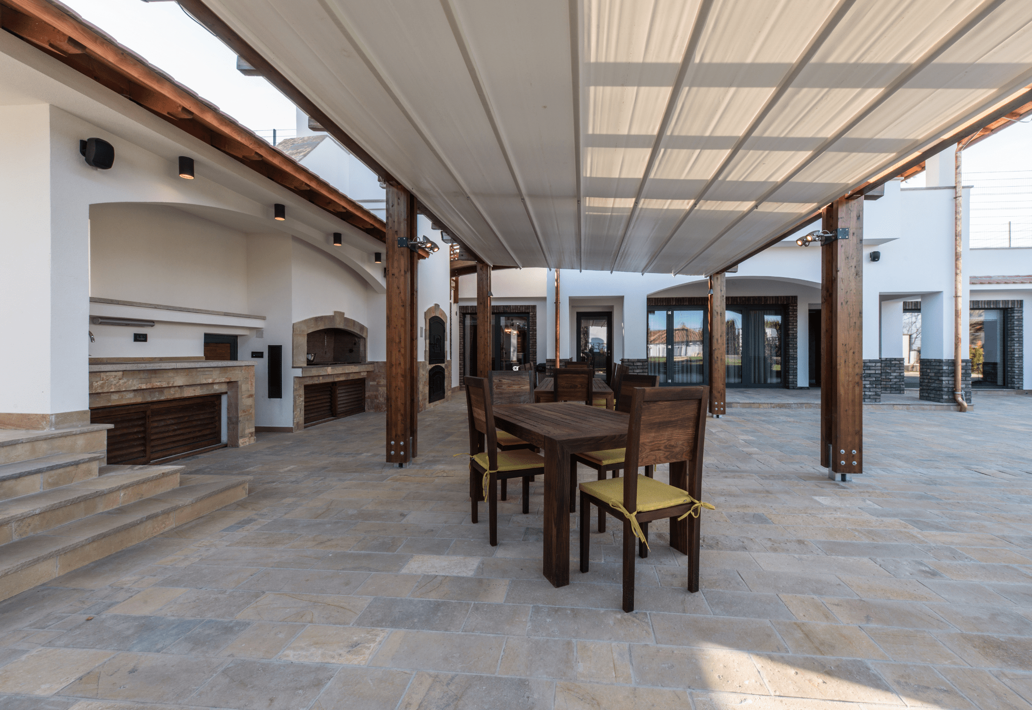 Fabric shade awnings over a patio on a pergola.