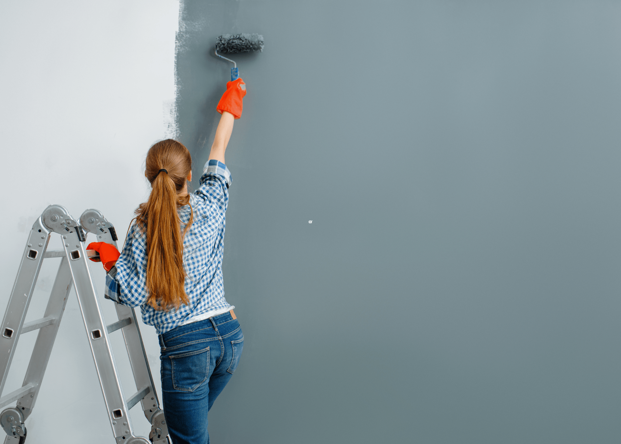 woman painting a wall with roller