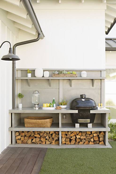 Patio features gray built-in shelving housing BBQ and nook to hold cut firewood.