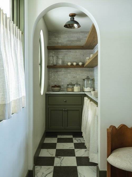 Kitchen features a small green pantry with black and white marble checkered floor tiles and L shaped wooden shelves over gray marble offset backsplash tiles.