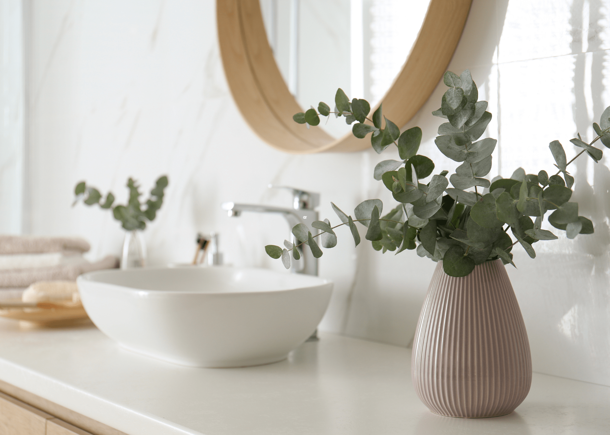 eucalyptus on bathroom counter with white bowl sink