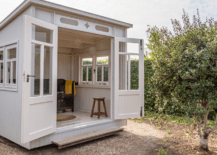 A white themed shed with open doors.