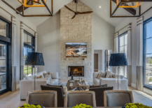 A living room with vaulted ceiling and stone fireplace.