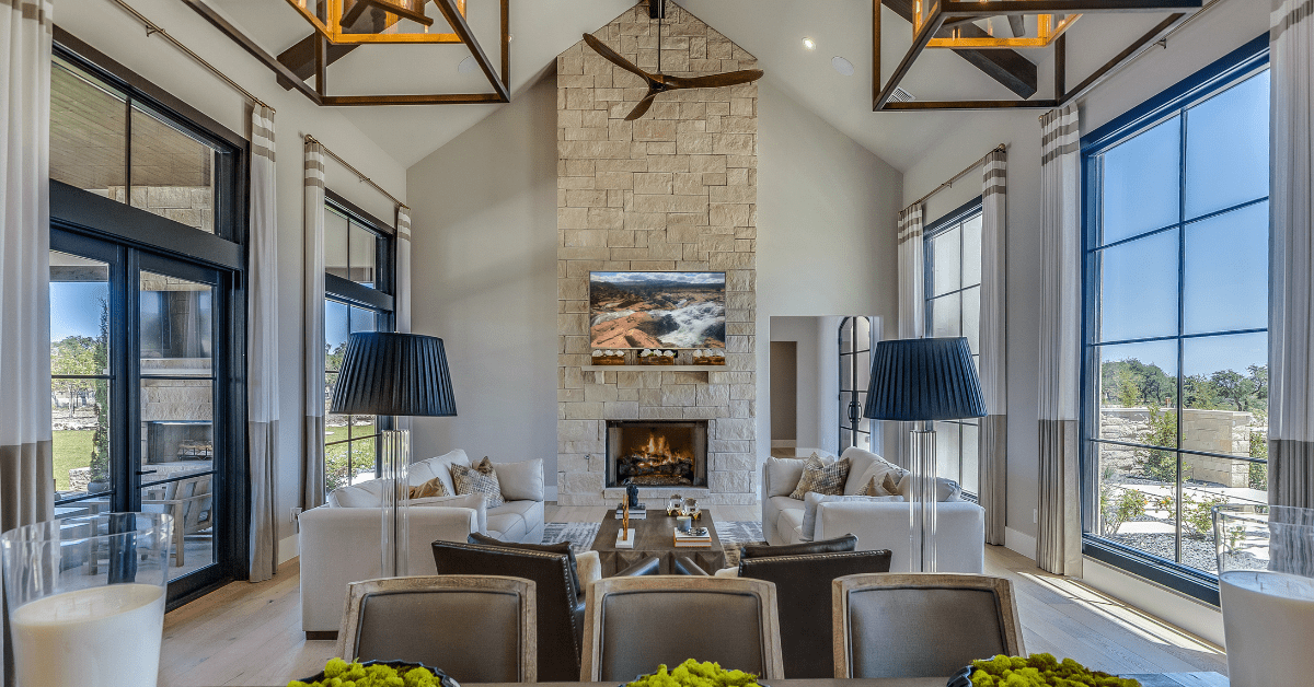 A living room with vaulted ceiling and stone fireplace.