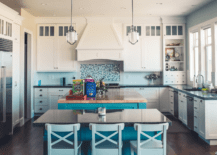 A spacious white and blue kitchen with a large island.