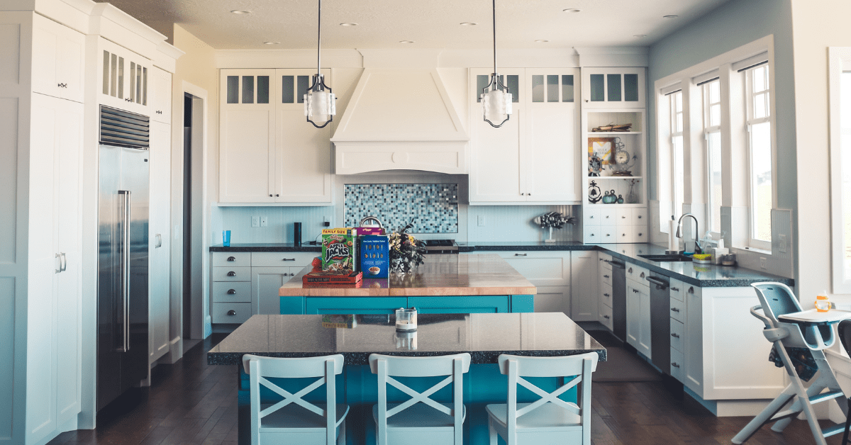 A spacious white and blue kitchen with a large island.